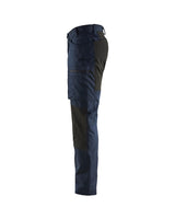 Side profile of lightweight service pants with stretch highlighting the pre-bent knees and zippered leg pockets.