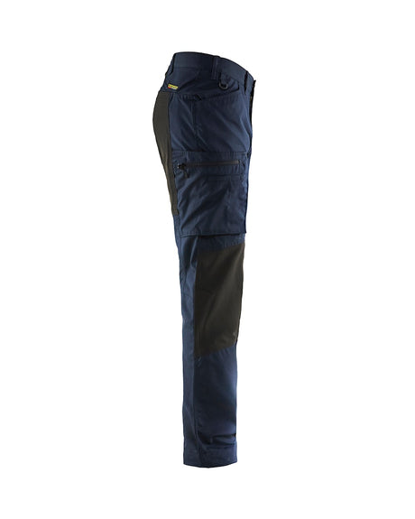Side profile of lightweight service pants with stretch highlighting the pre-bent knees and zippered leg pockets.